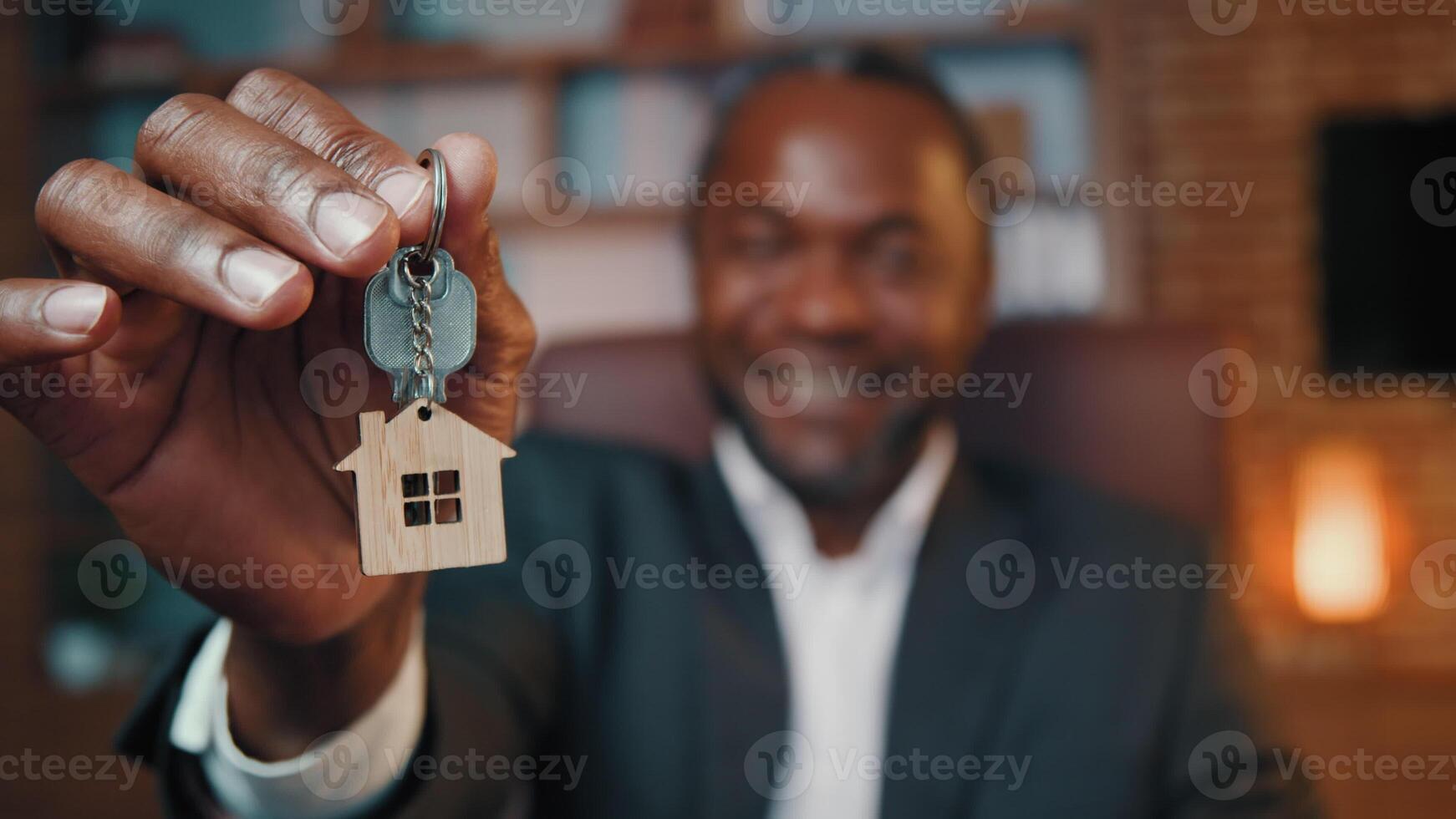 Close-up mature african american man hold keys new home blurred male real estate agent demonstrate key sell property give affordable housing make special offer happy ethnic homeowner winning apartment photo