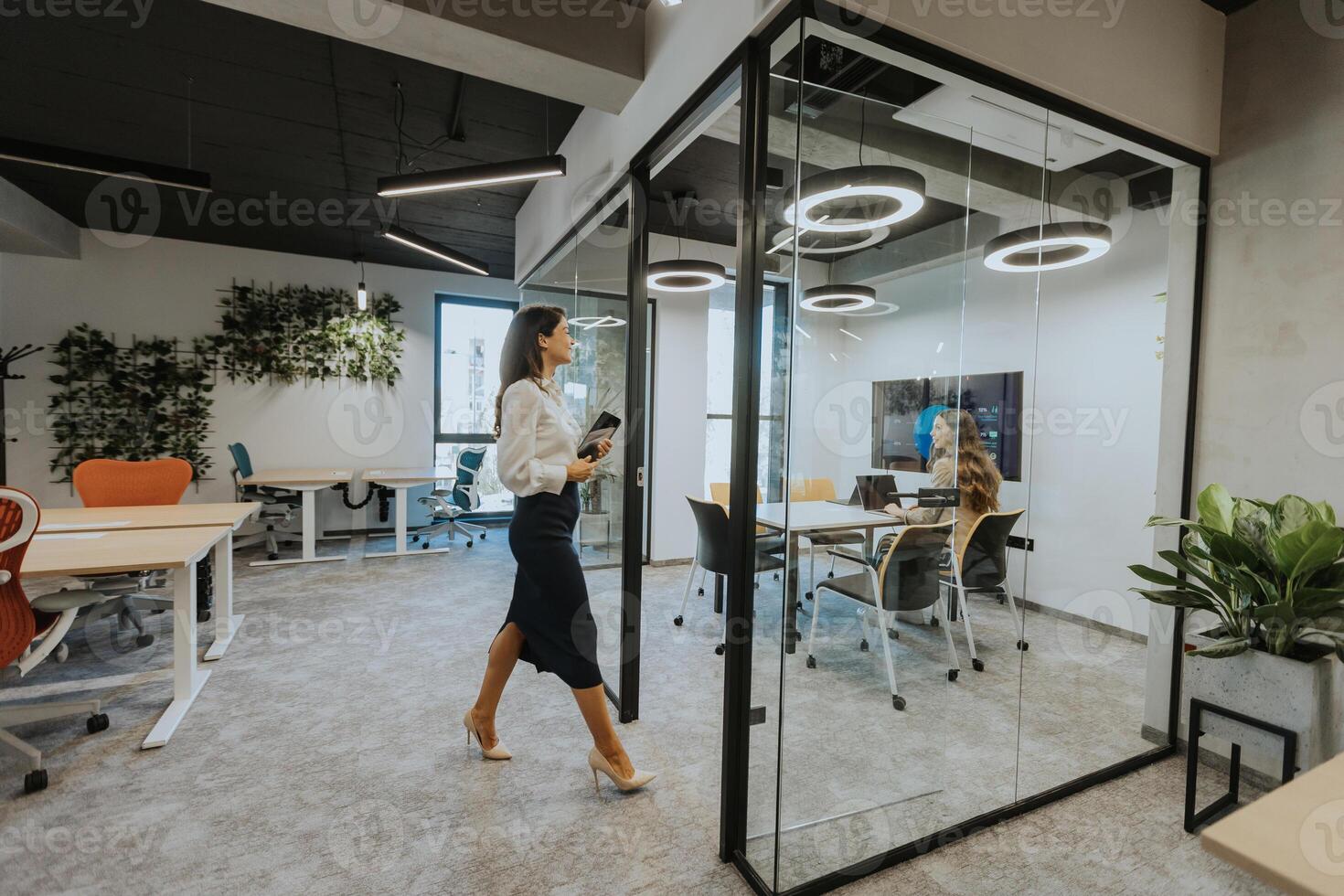 Young woman with digital tablet walking in the modern office photo