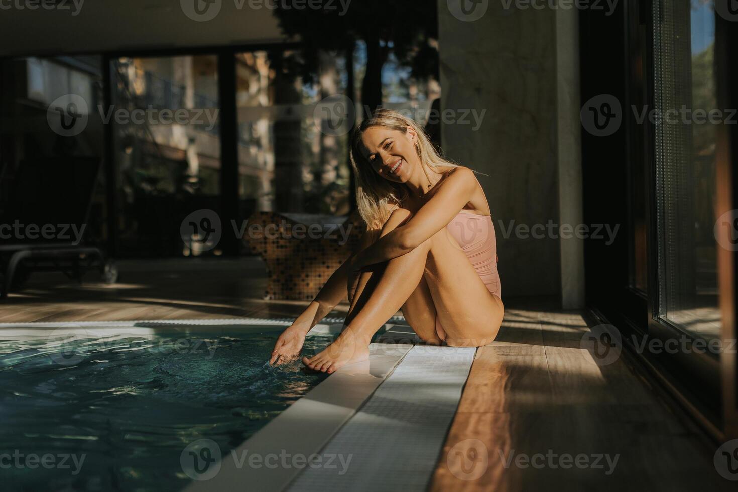 Young woman relaxing by the indoor swimming pool photo