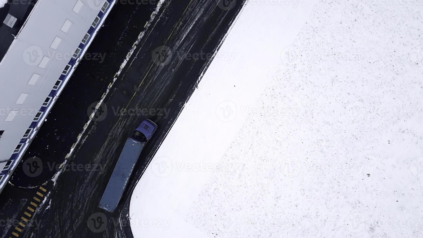 Moving a huge blue truck. Bird's-eye view. Creative. Winter landscape where a large car transports goods. photo