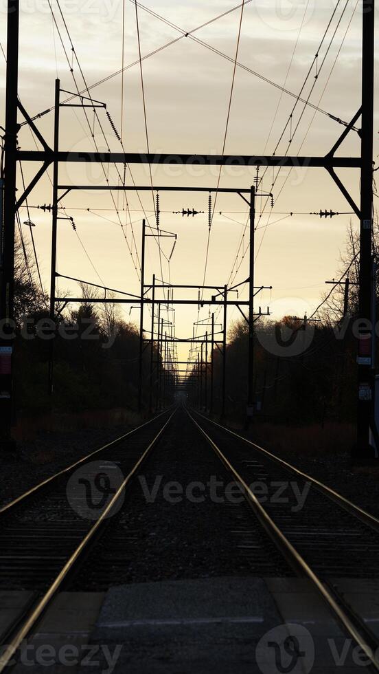 The railway view with the track and the colorful woods as background in the autumn morning photo