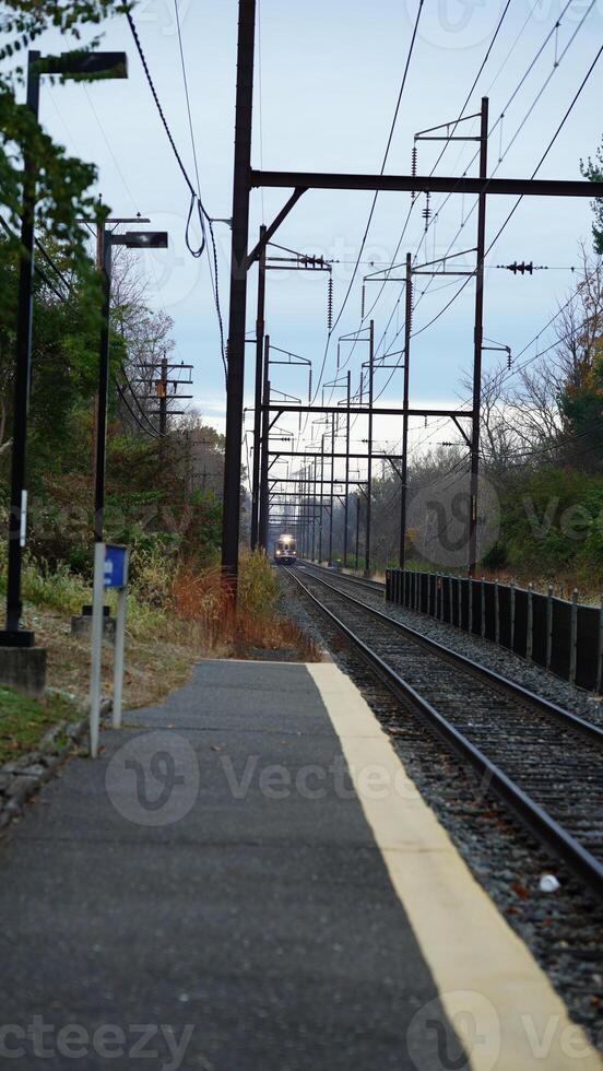 The railway view with the track and the colorful woods as background in the autumn morning photo