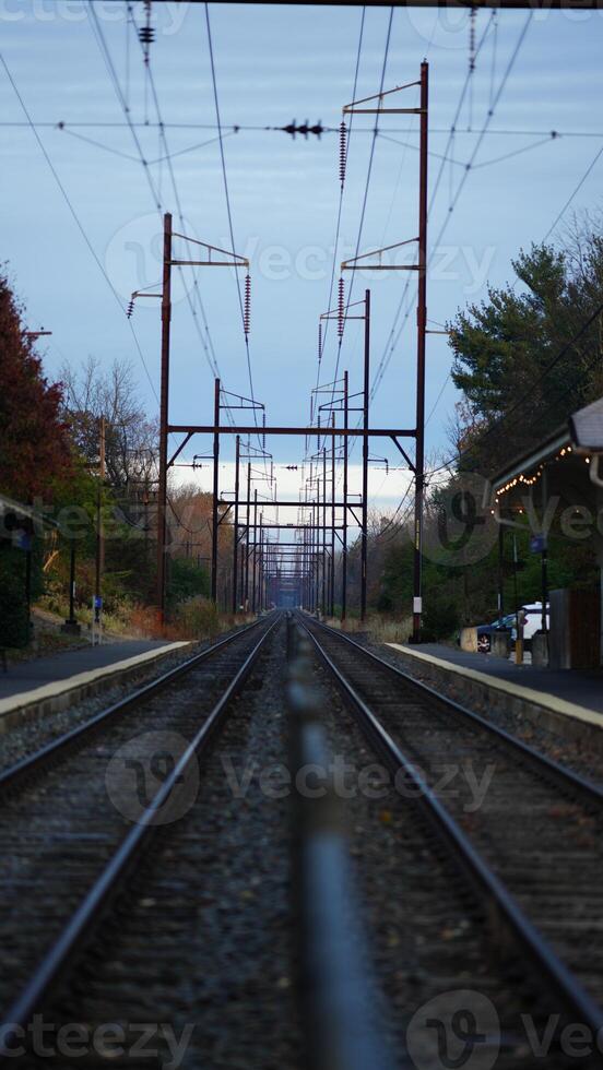 The railway view with the track and the colorful woods as background in the autumn morning photo