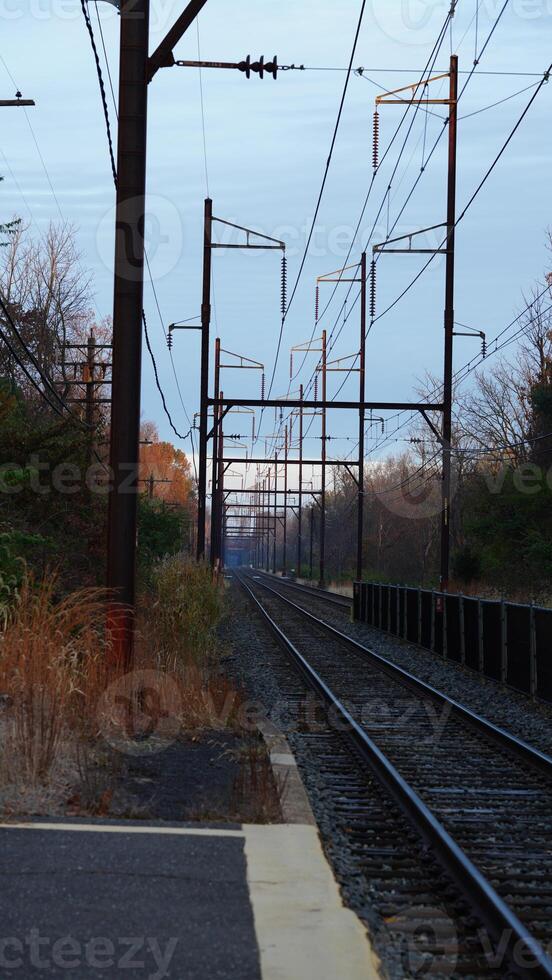 The railway view with the track and the colorful woods as background in the autumn morning photo