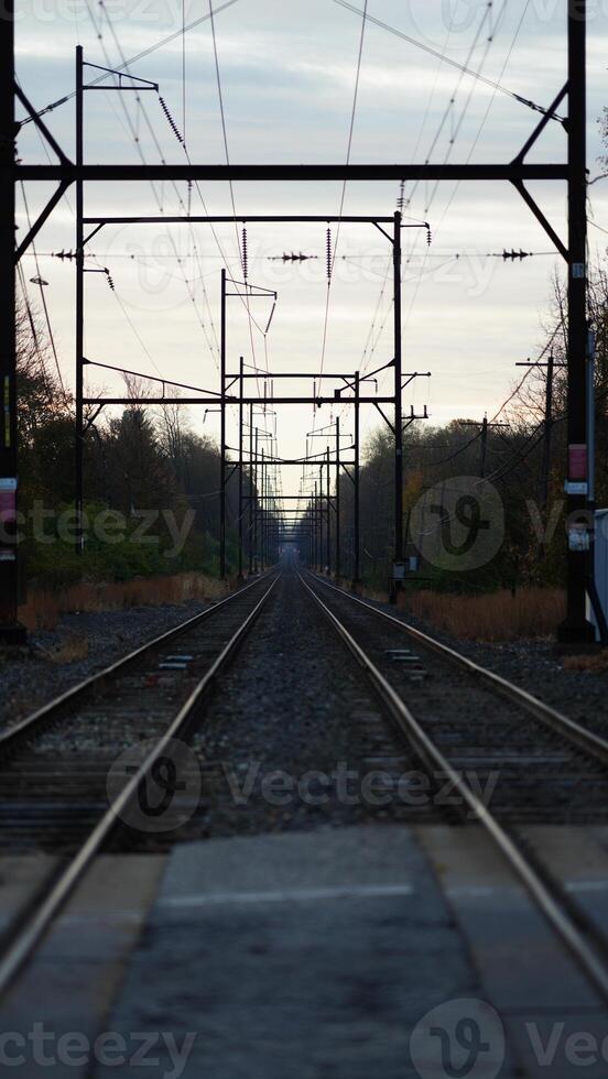 The railway view with the track and the colorful woods as background in the autumn morning photo
