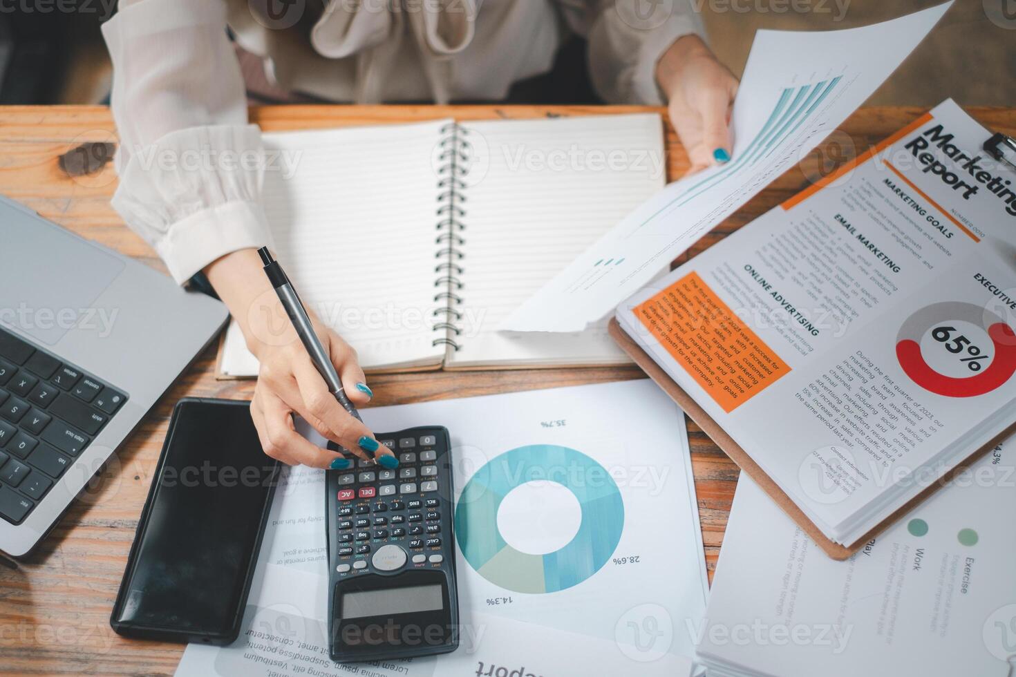 Business woman using calculator and analysis summary graph reports of business operating expenses and work data about the company's financial statements. photo