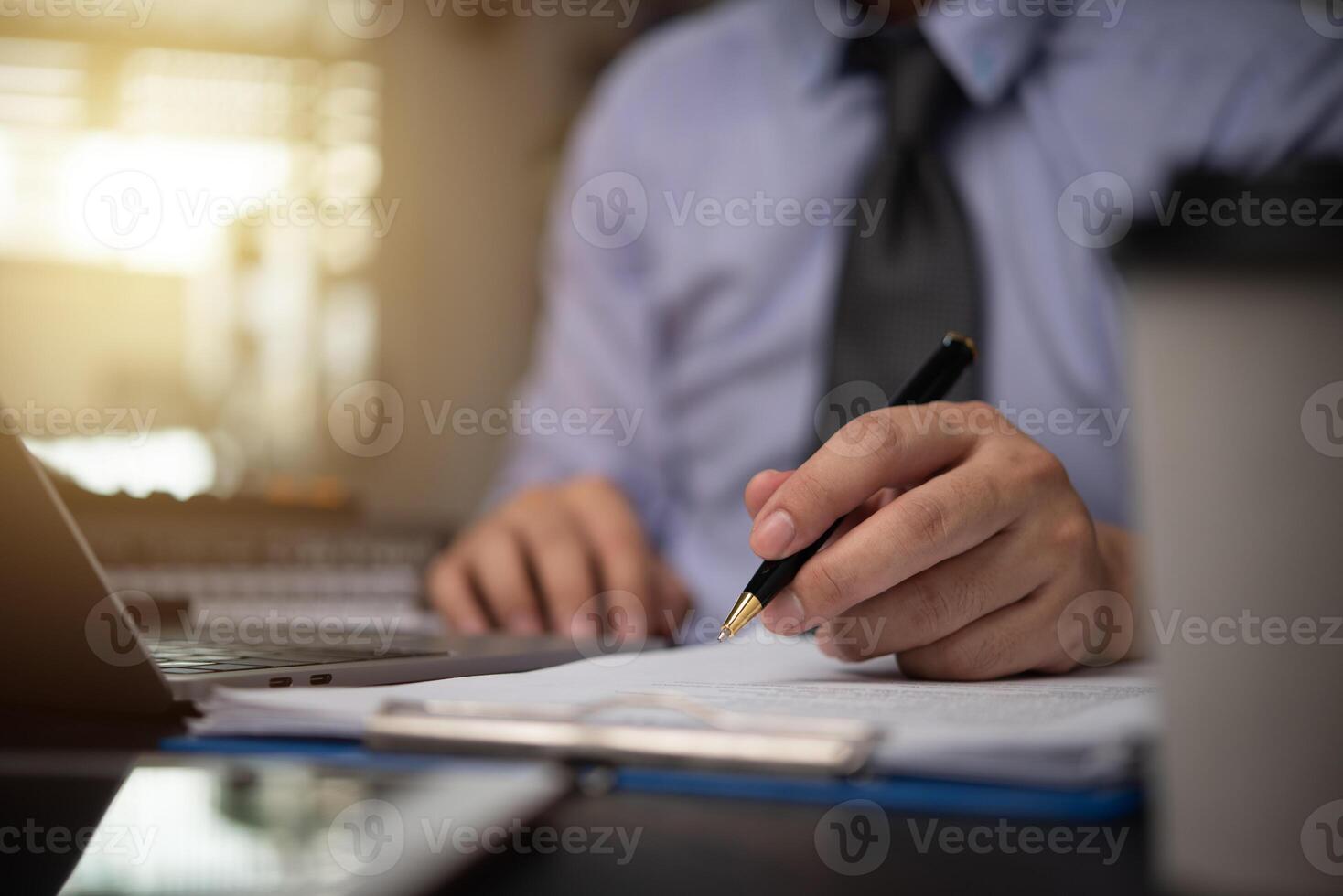 man hands with pen writing on notebook in the office.learning, education and work.writes goals, plans, make to do and wish list on desk.. photo