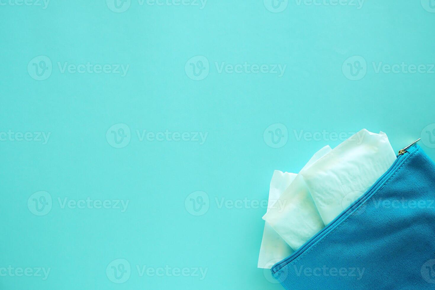 Sanitary napkin in women's fabric bag on blue background photo