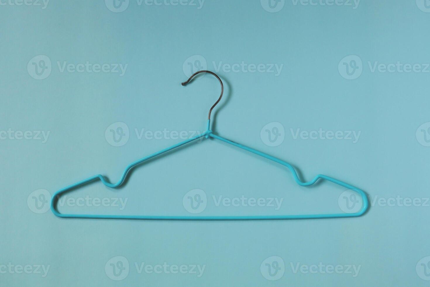 Clothes hangers on blue background photo