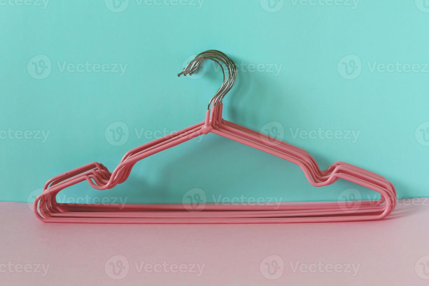 Clothes hangers on blue-pink background photo