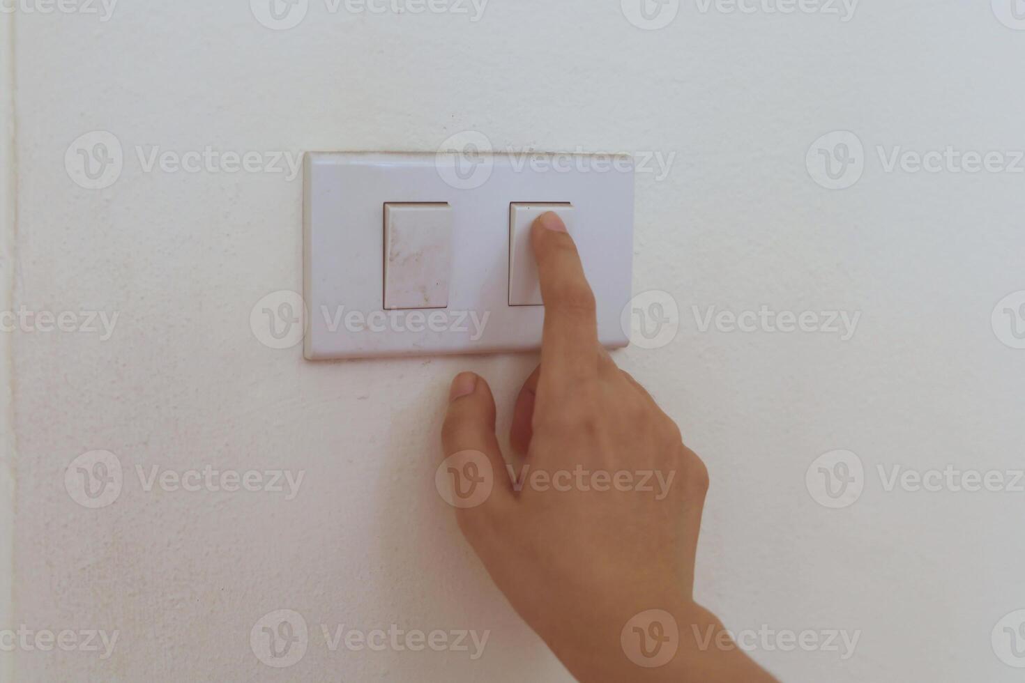 Hand pressing the button to turn the light on or off photo