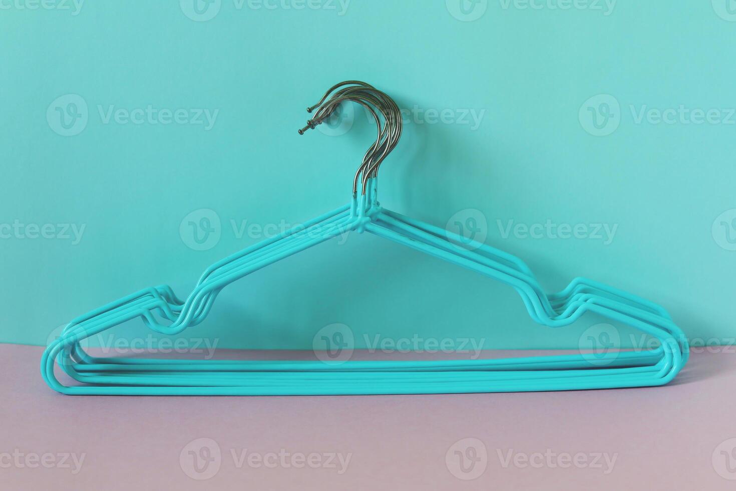 Clothes hangers on blue-pink background photo