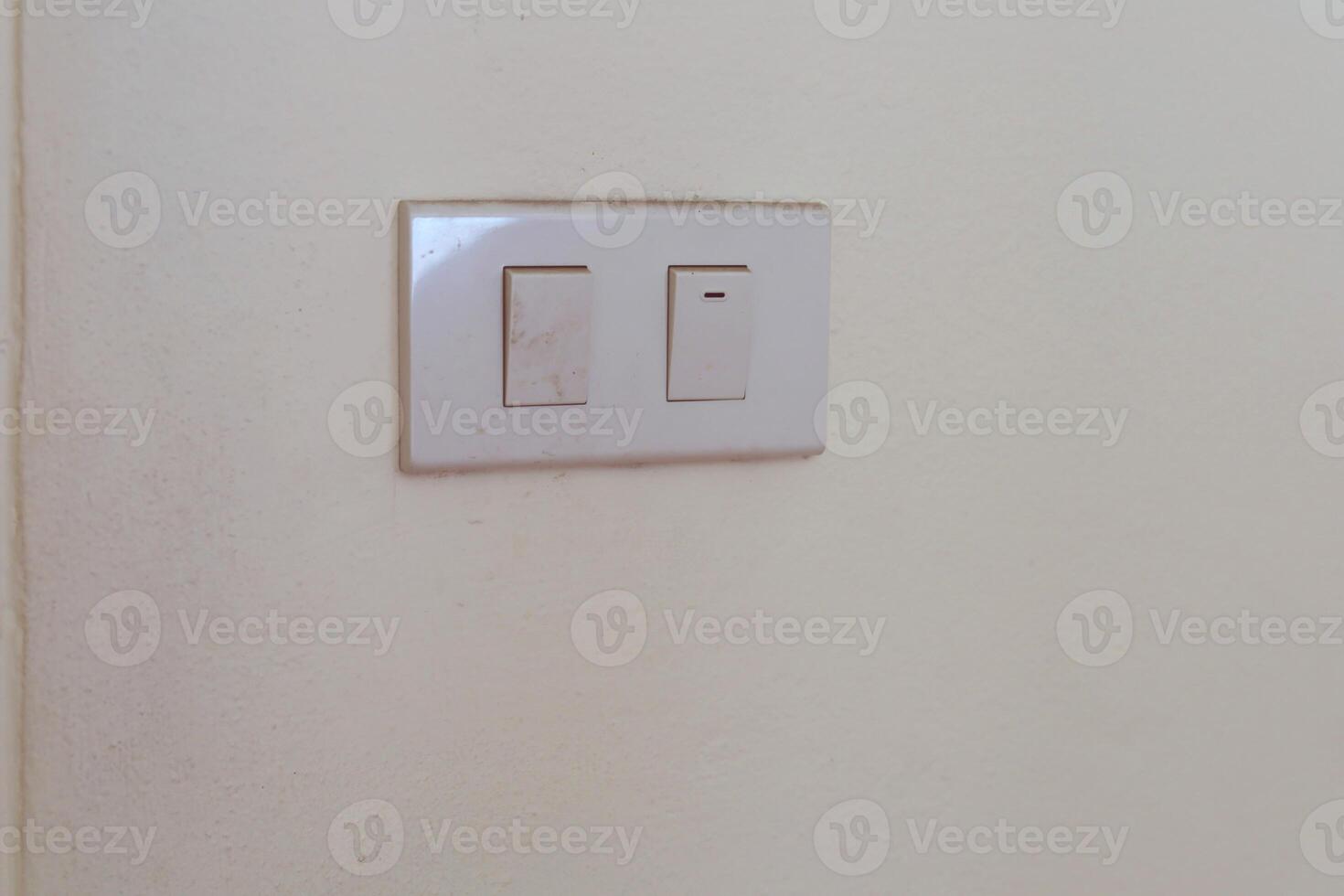 White electrical switch plate on the wall for control the light turning on or off photo