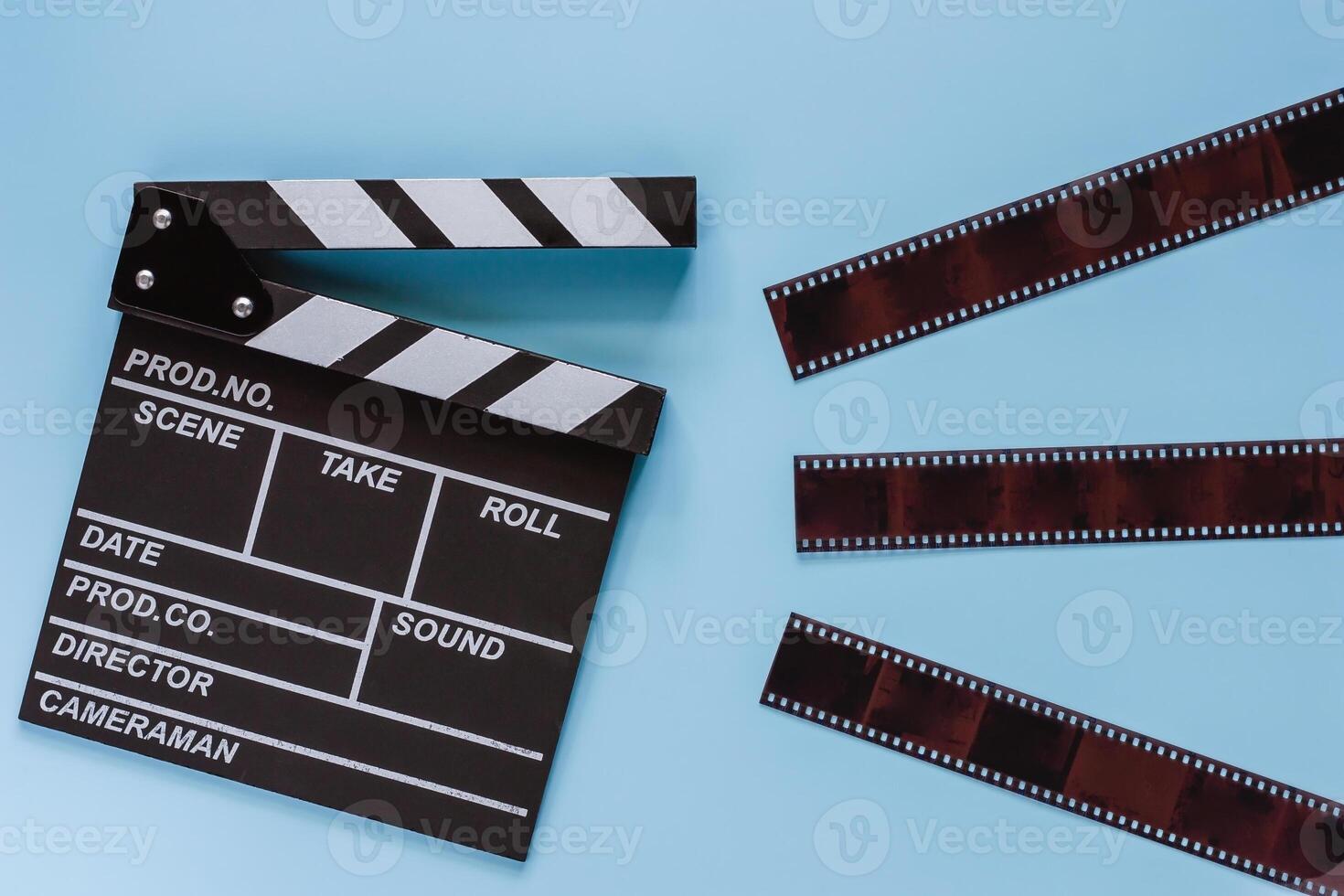 Movie clapper board with film on blue background photo