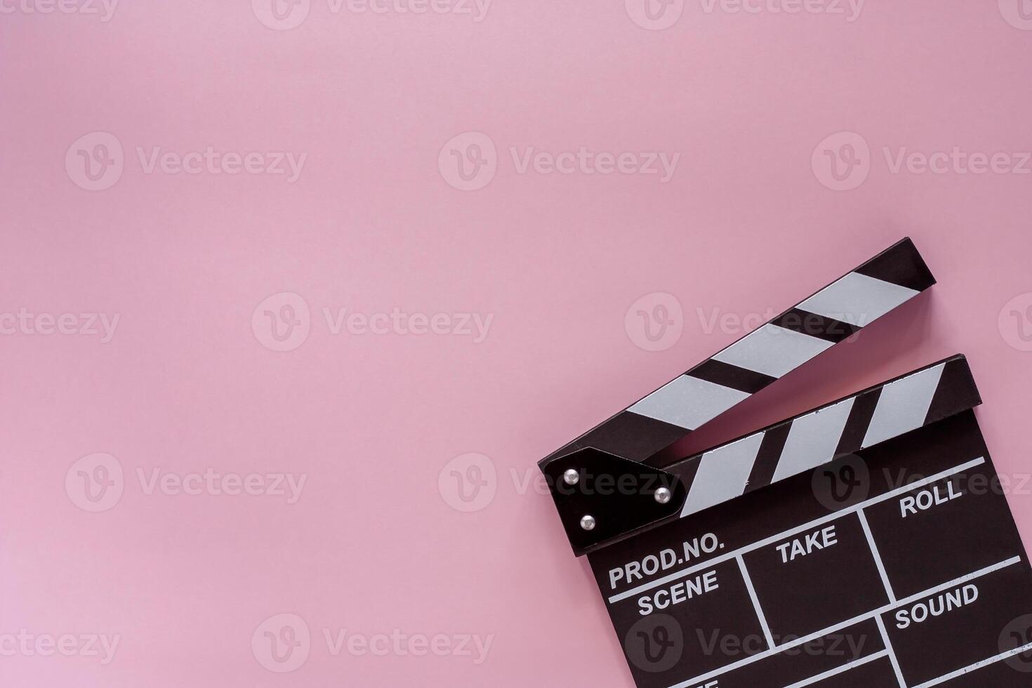 Movie clapper board on pink background photo