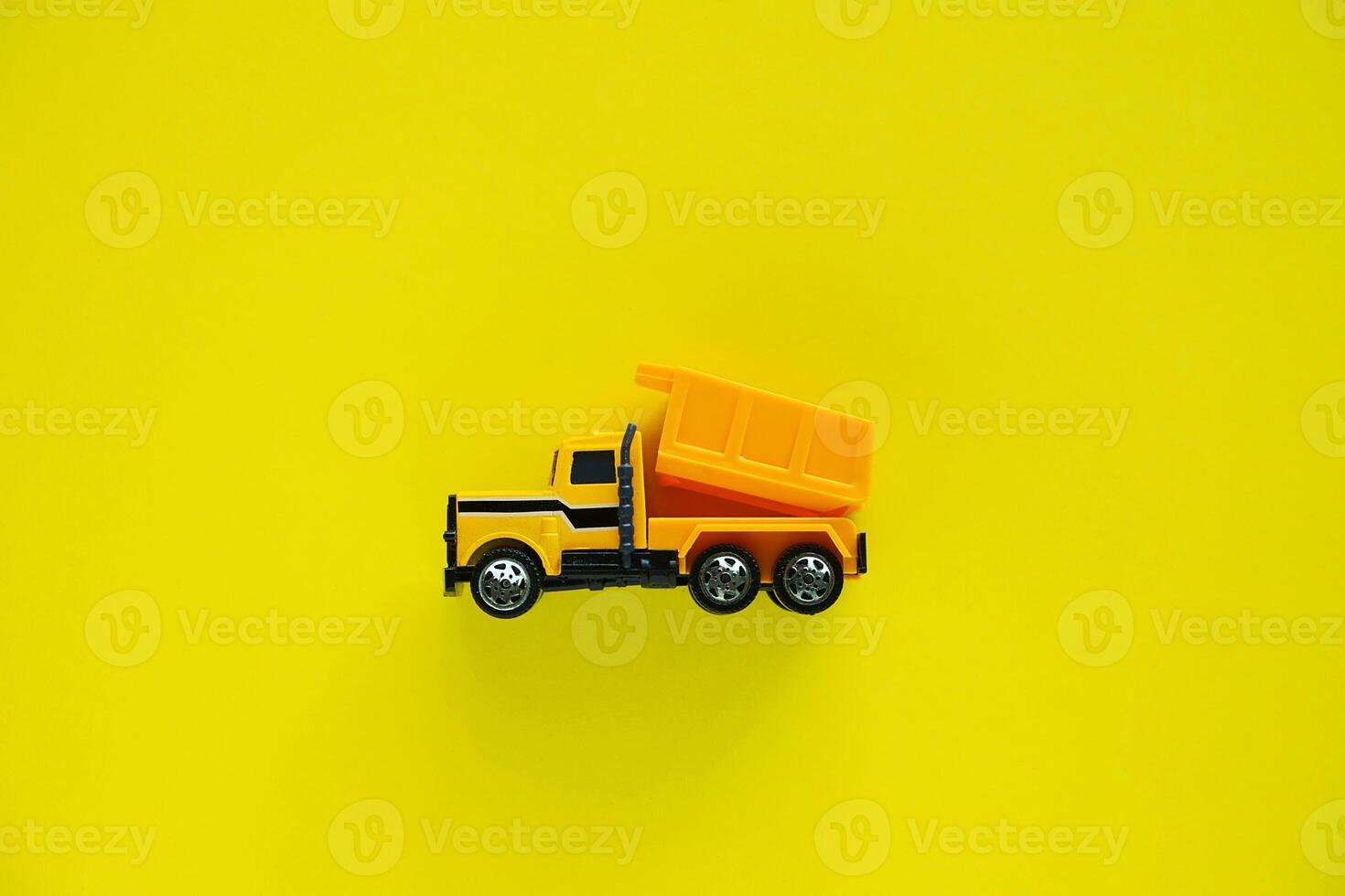 Mini toy dump truck on yellow background photo