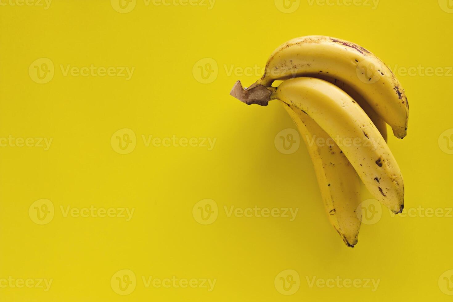 Bunch of bananas on yellow background photo