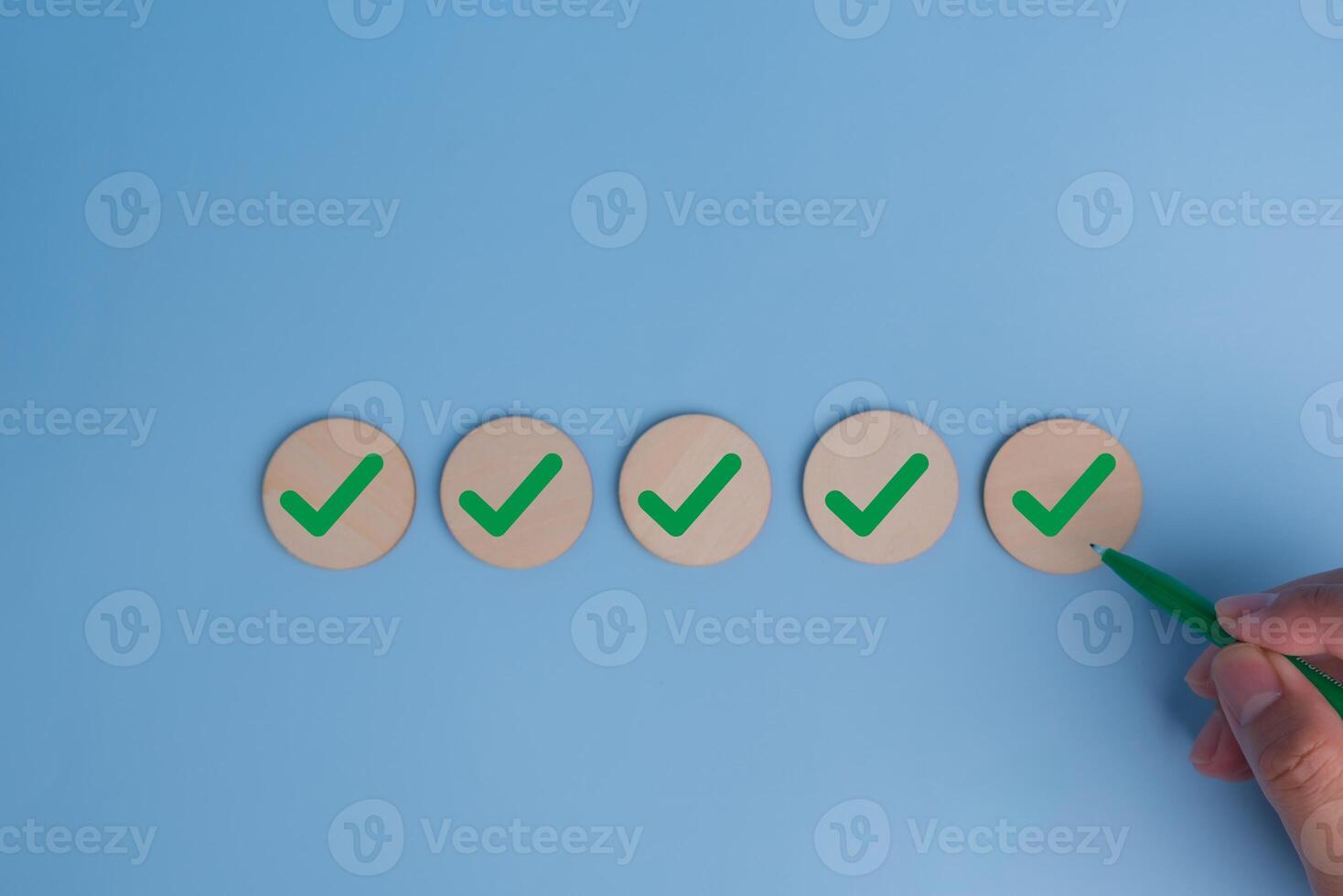 hand holding pen check mark on blue background. Business quality target strategy marketing concept. photo