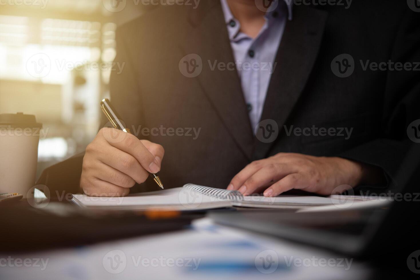 man hands with pen writing on notebook in the office.learning, education and work.writes goals, plans, make to do and wish list on desk. photo
