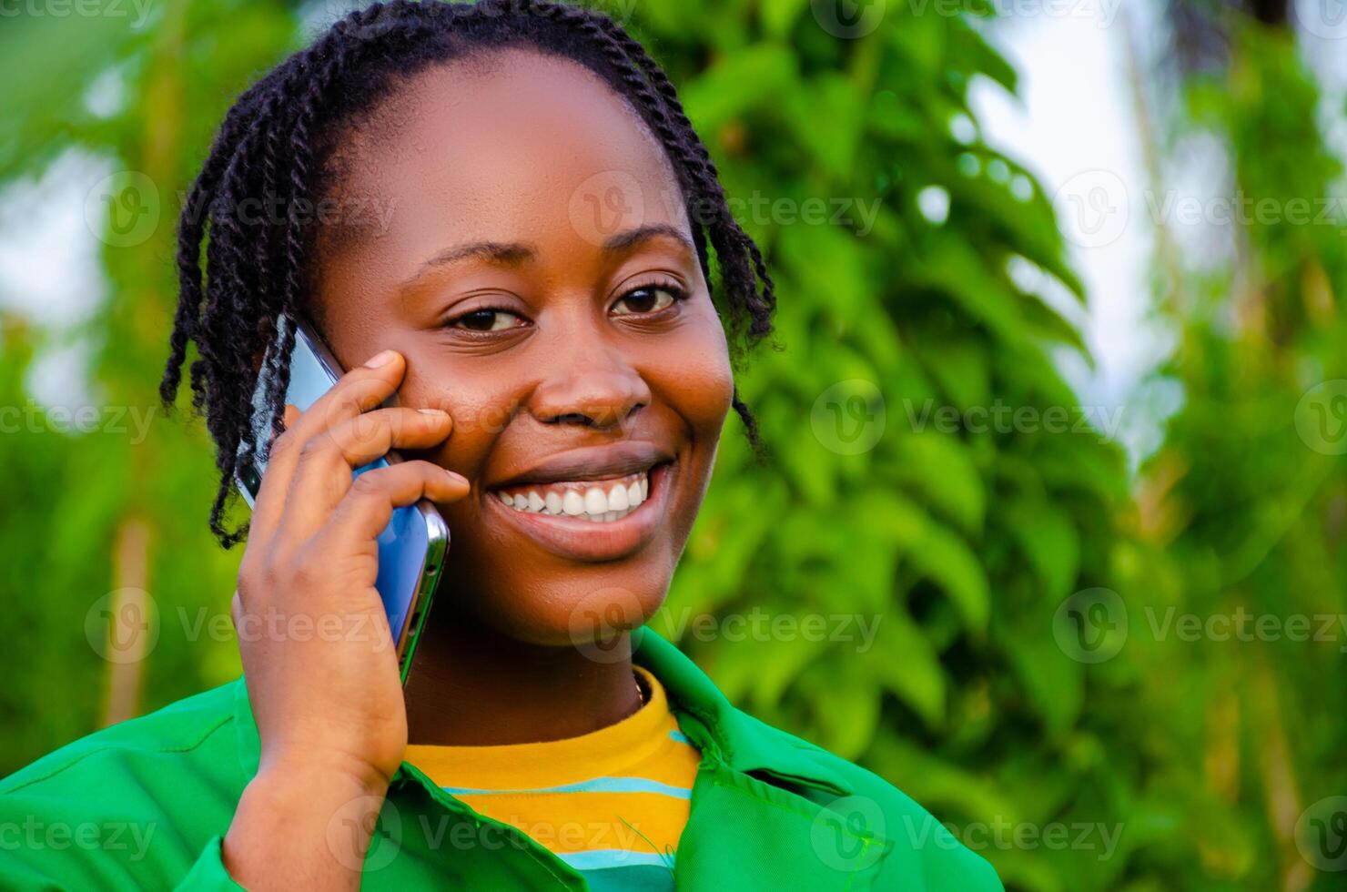 close up of a beautiful lady in the farm smiling as she is making call photo