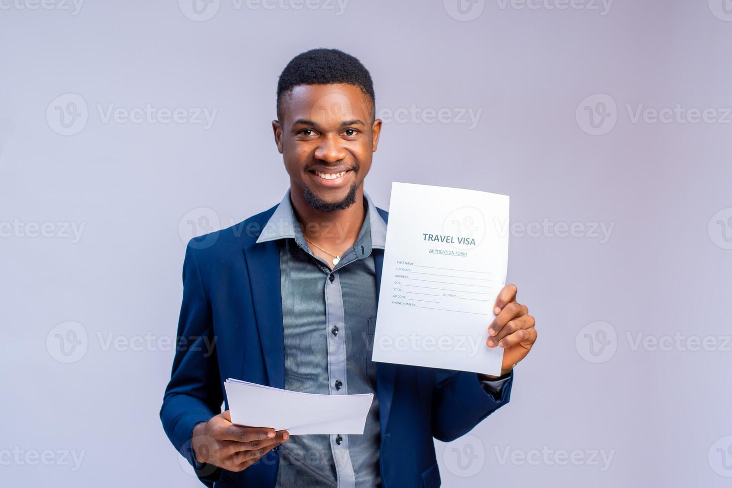 handsome young travel agent smiling as he holds visa application form photo