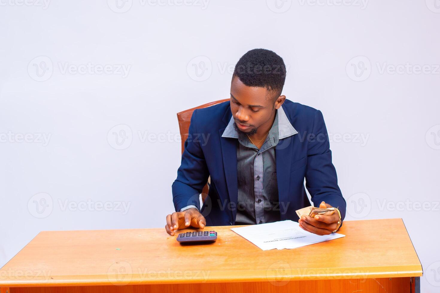 handsome african business using calculator to calculate his expense photo