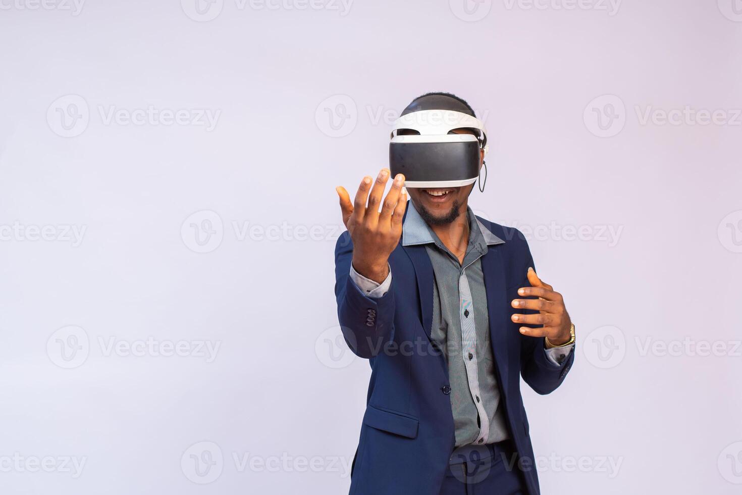 Close up portrait of handsome man playing video games in goggles or 3d glasses. african player wearing virtual reality headset for smart phone on his head, smiling, standing against white background photo