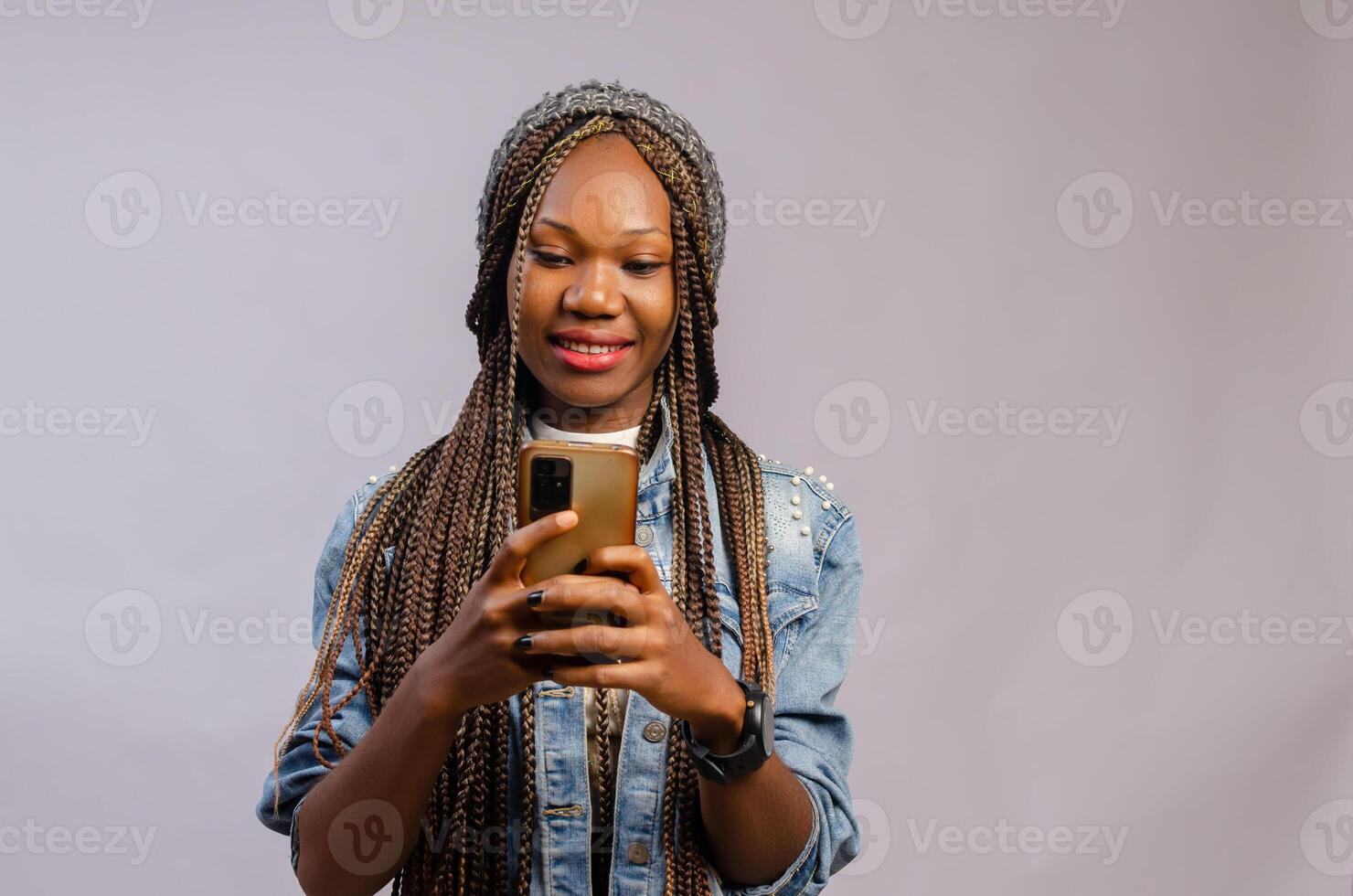 lady smiling as she operates her phone photo