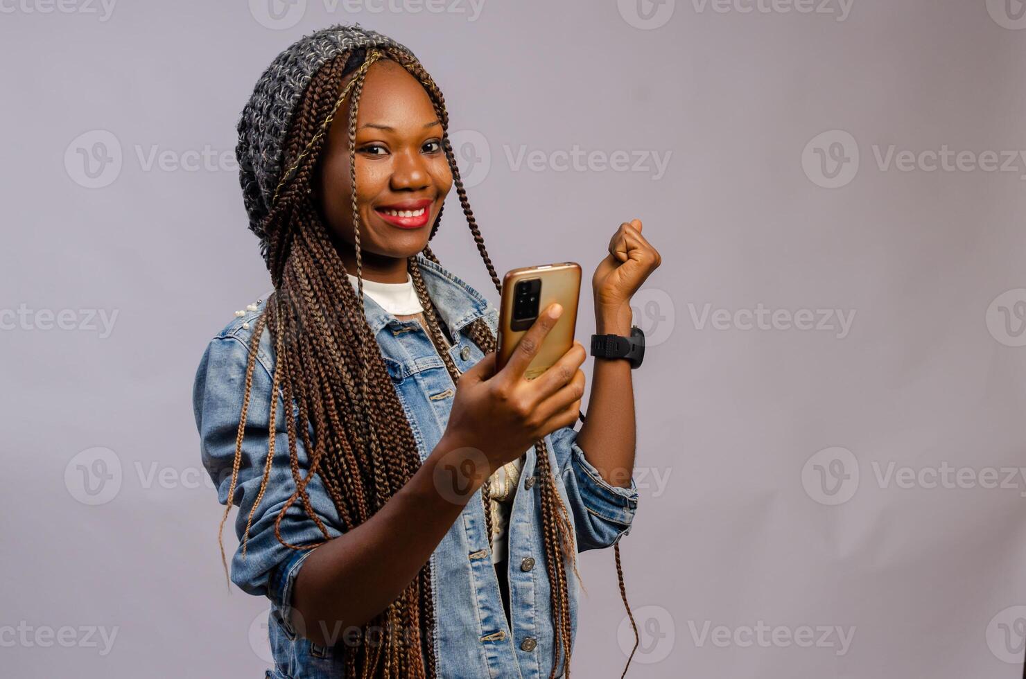 african lady wearing a casual cloth feeling excited about what she saw on her phone photo