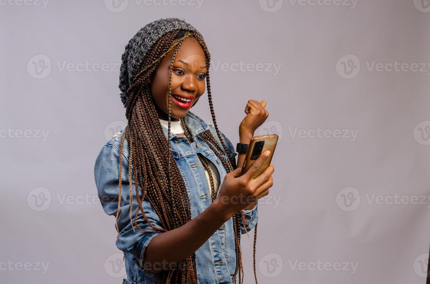 cute african lady wearing a casual cloth feeling excited about what she saw on her phone photo