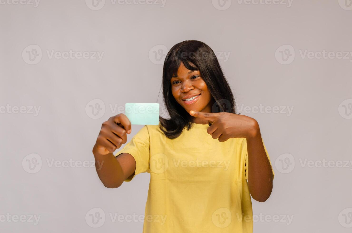 A woman smiling as she holds a business card in front of her photo