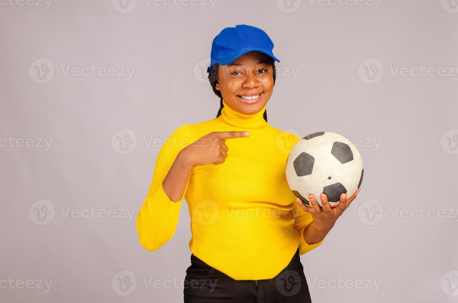 pretty lady smiling pointing to the ball on her hand photo