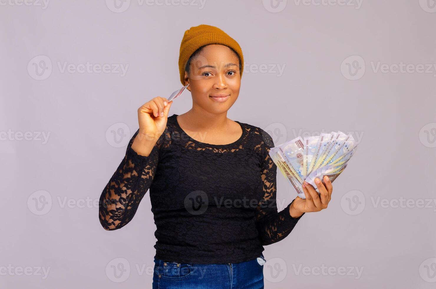 Happy young woman holding money and credit card. photo