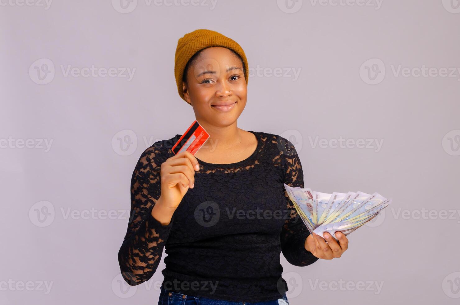 Happy young woman holding money and credit card. photo
