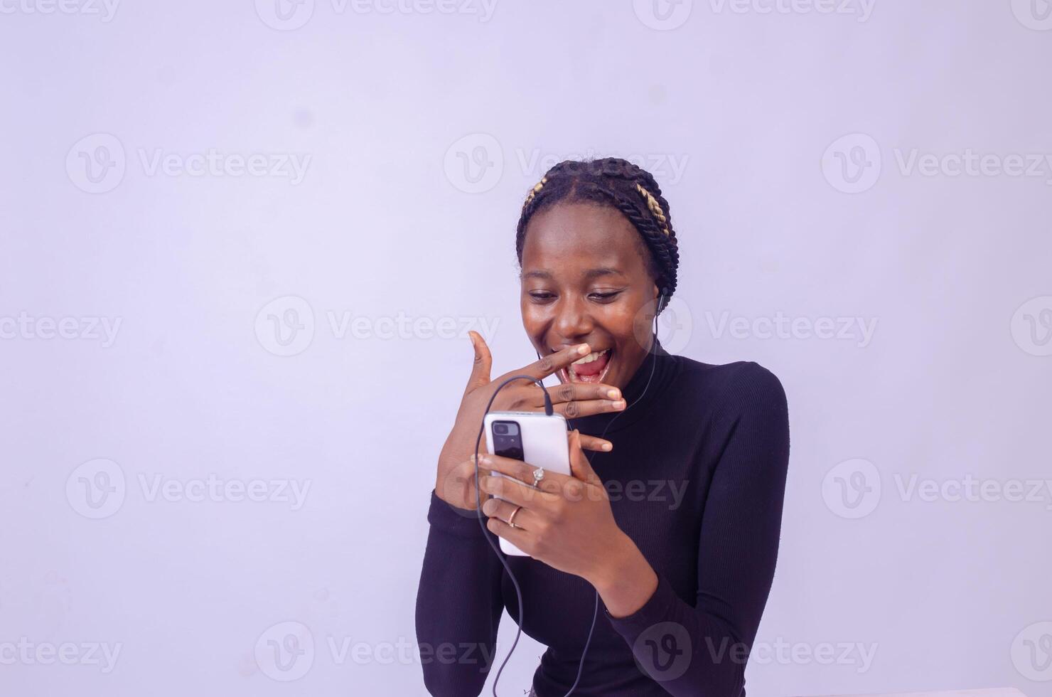 excited african lady isolated over white background listening to music on her phone photo