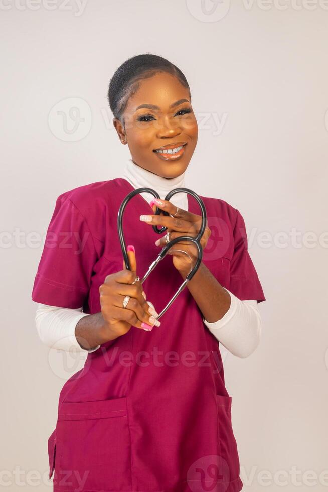 close up of a beautiful nurse smiling as she did love shape with her stethoscope photo