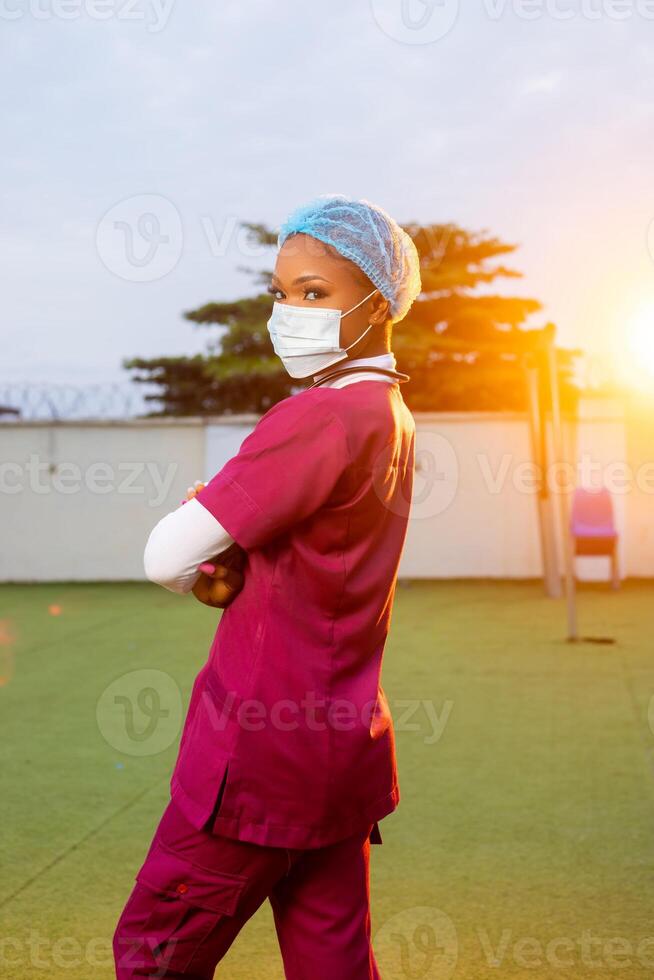 Young black female healthcare worker smiling outside, portrait photo