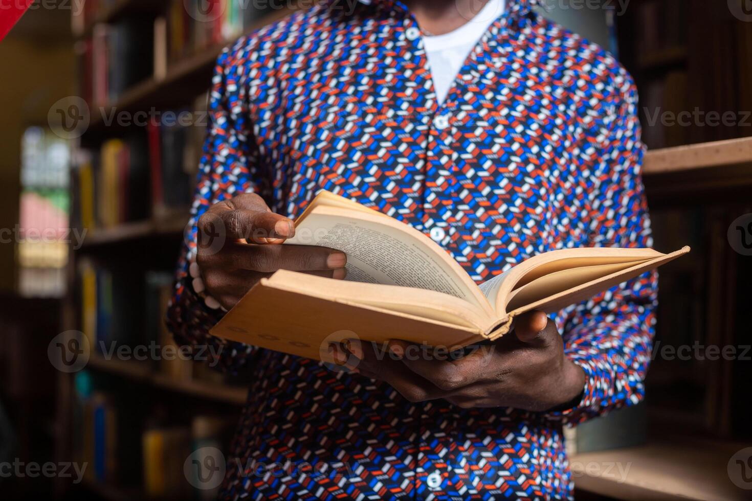 close of a guy in the library reading for exam photo