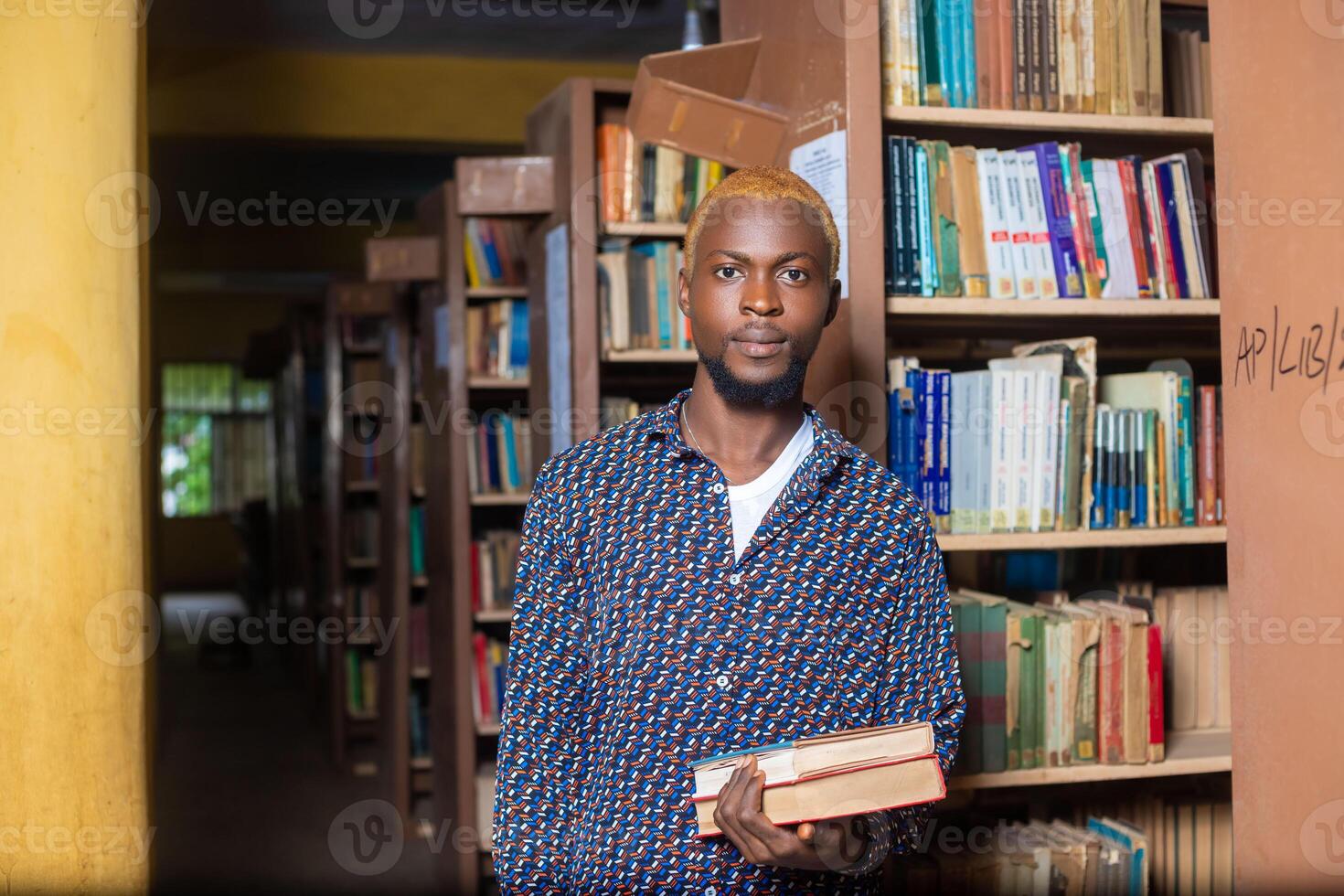 close up of a handsome male reading books in the library photo