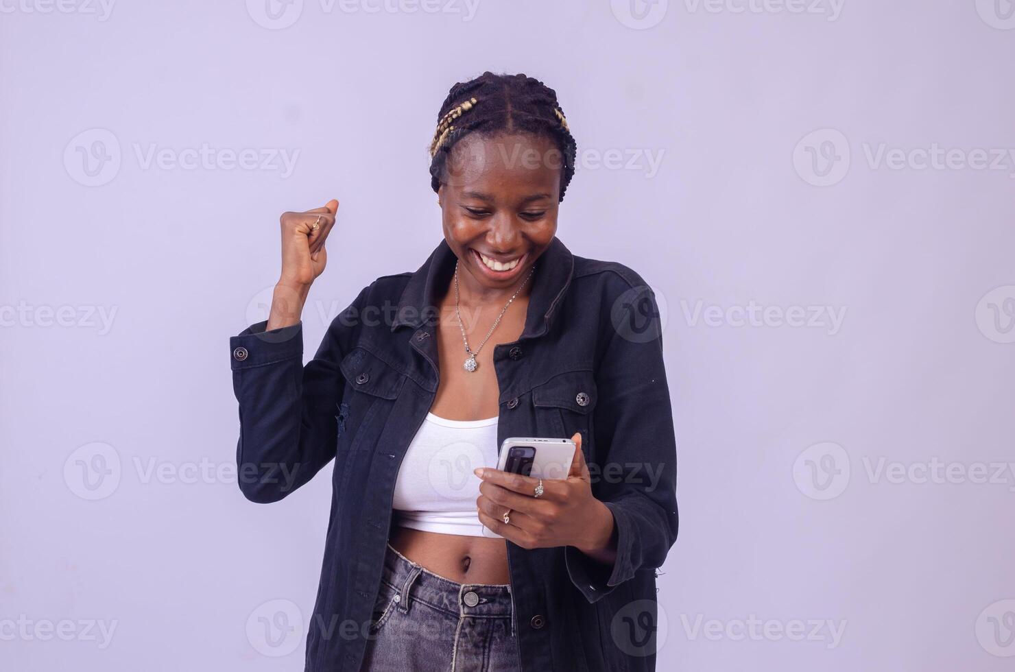 young black woman using her phone looking surprised photo
