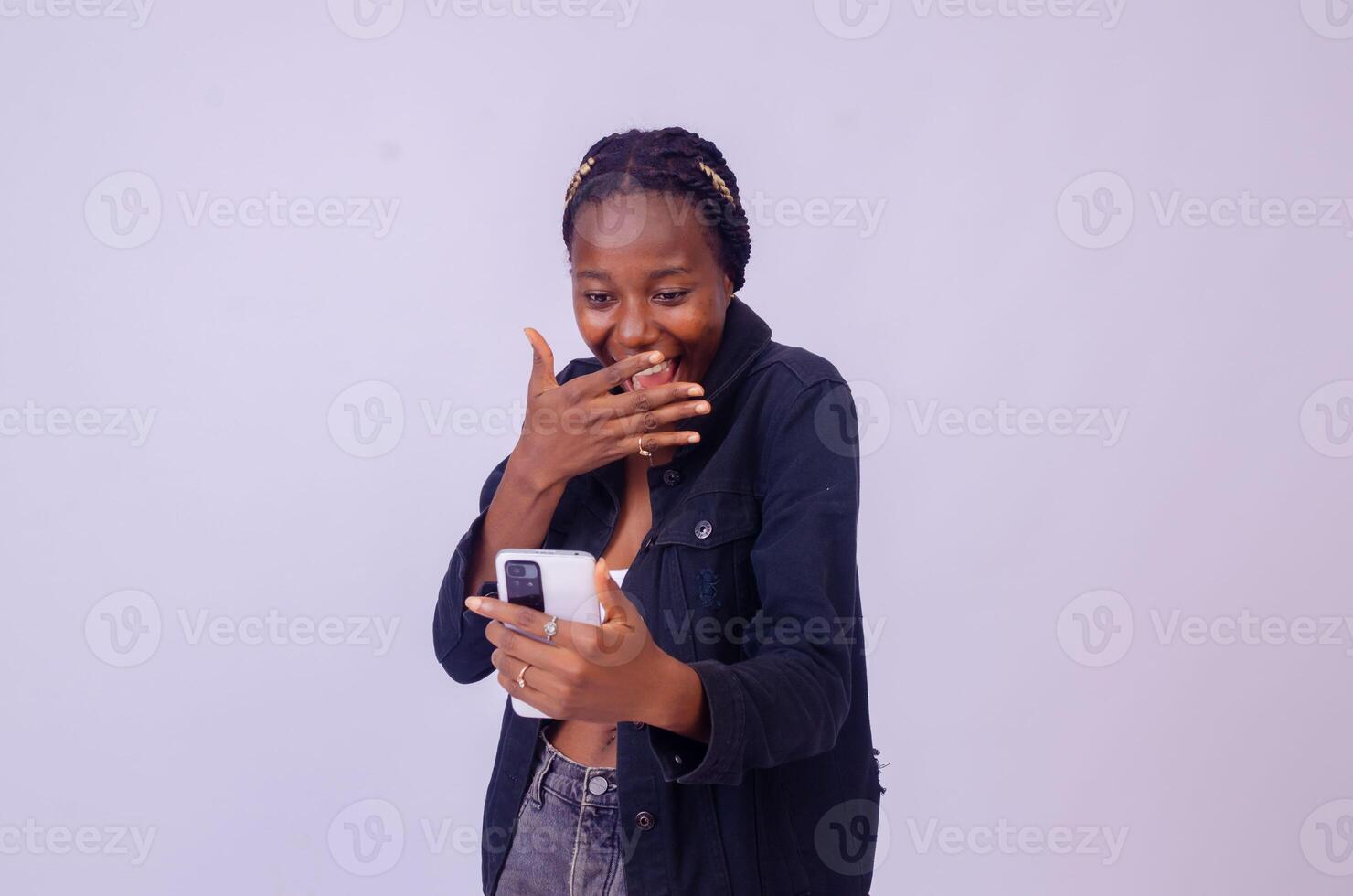 young black woman using her phone looking surprised photo