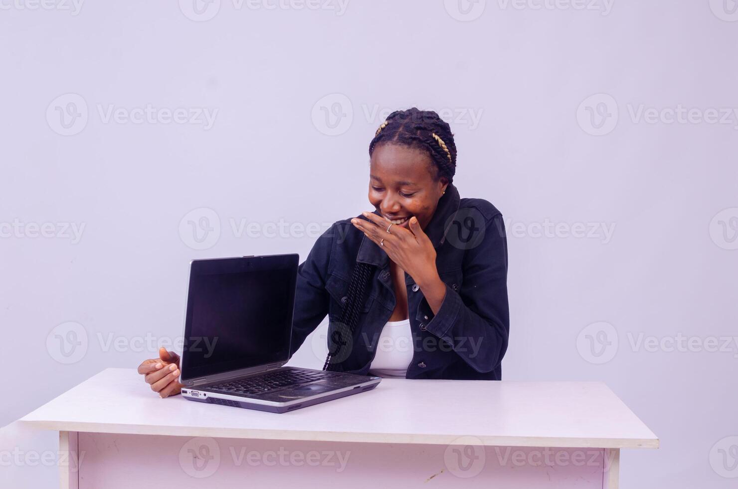 happy beautiful young black woman showing her laptop screen photo