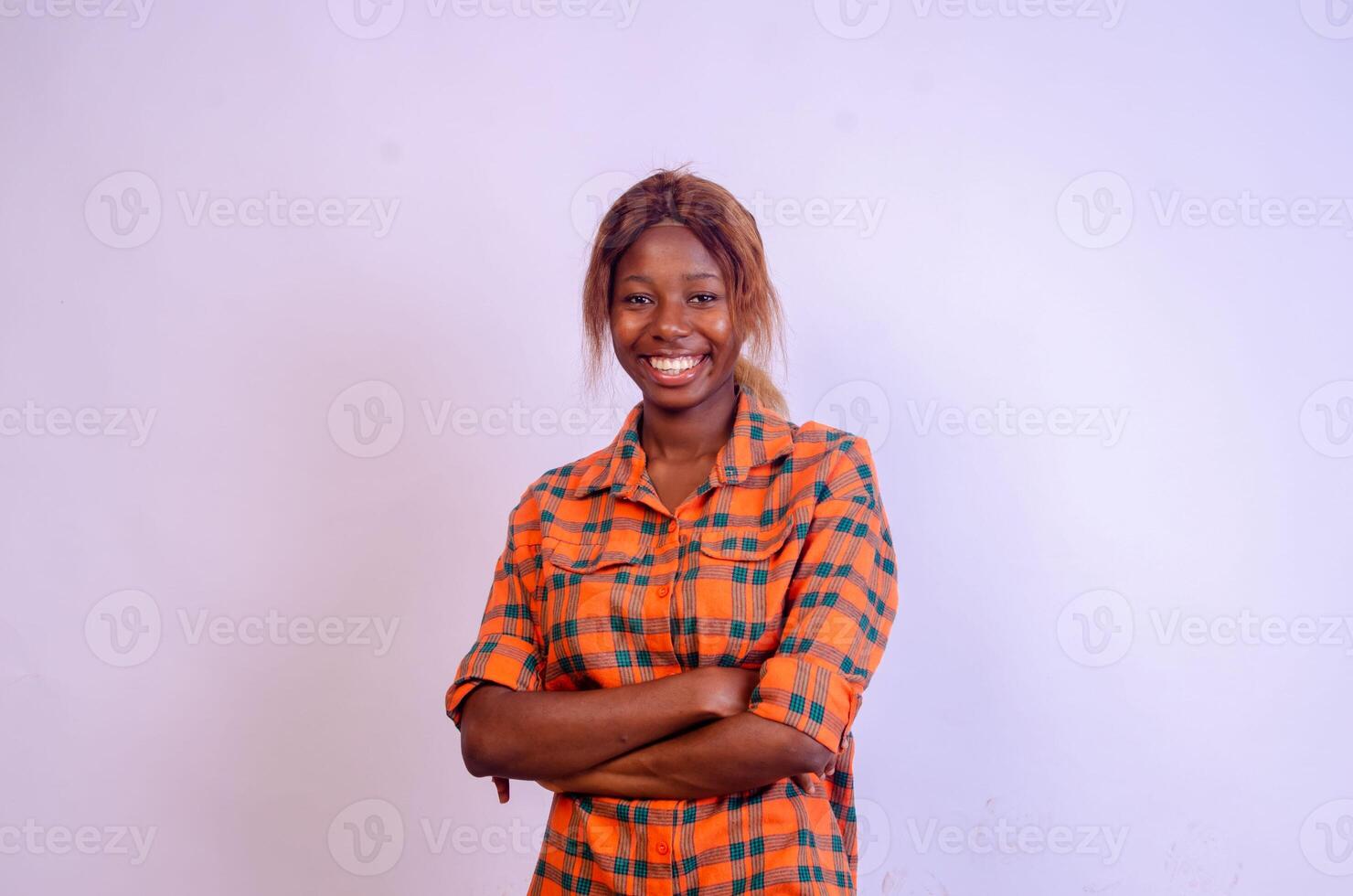 Confident woman. Confident young woman keeping arms crossed and smiling while standing isolated on white photo