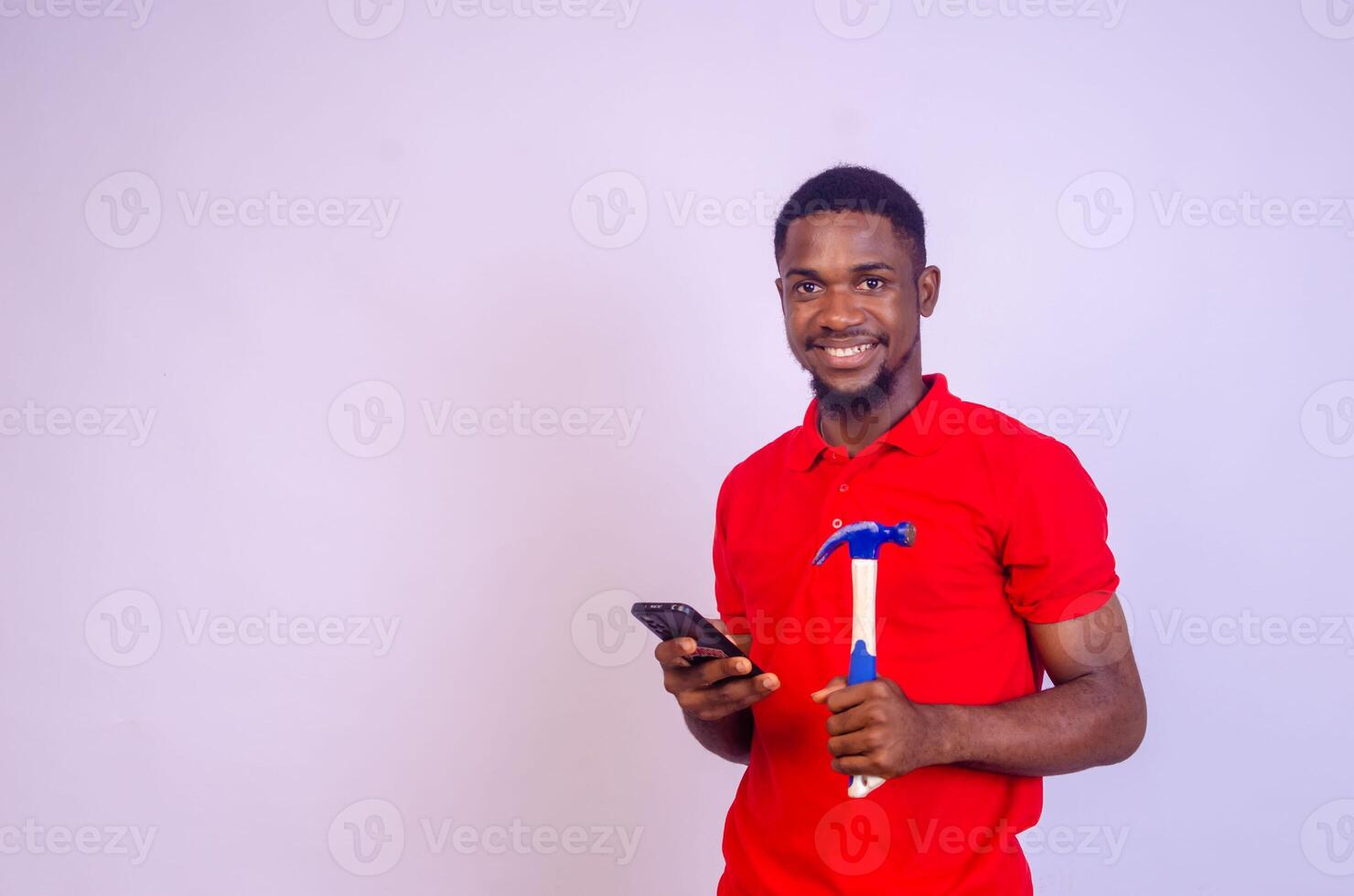 handsome carpenter smiling isolated over white background using phone photo