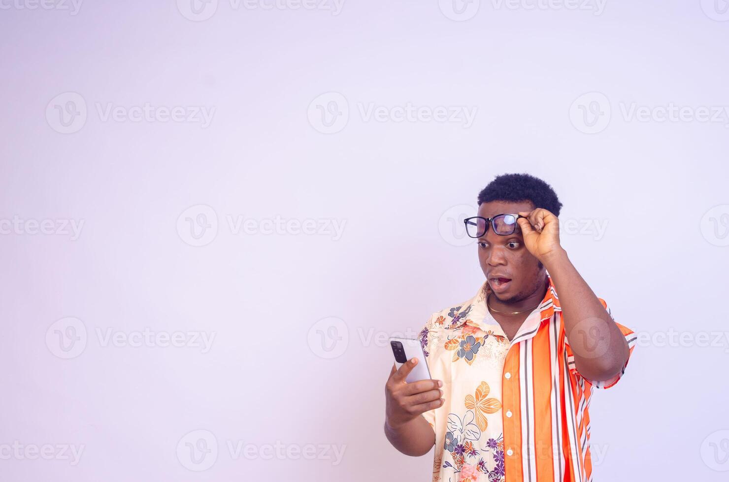 Cheerful African American man in white shirt using mobile phone application. photo