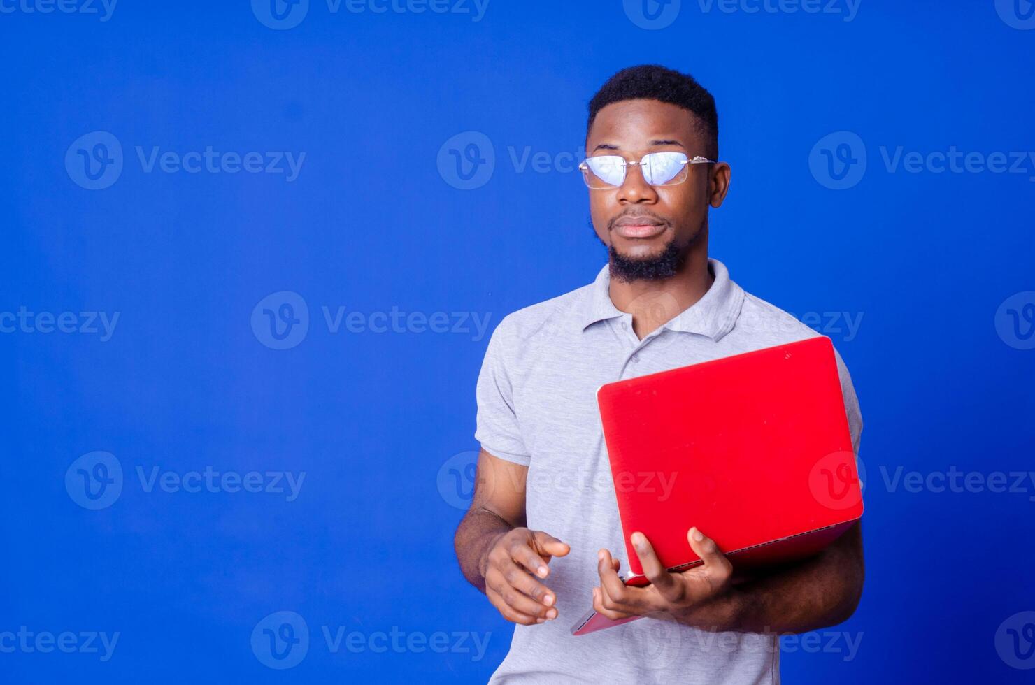 Young surprised african american man standing and using laptop computer photo