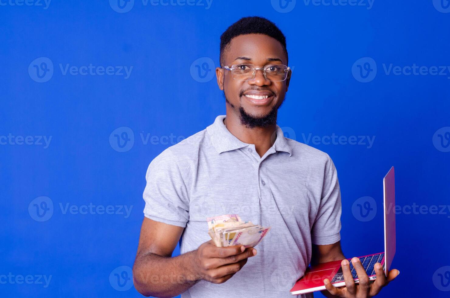 young african businessman holding a lot of money and using his laptop photo