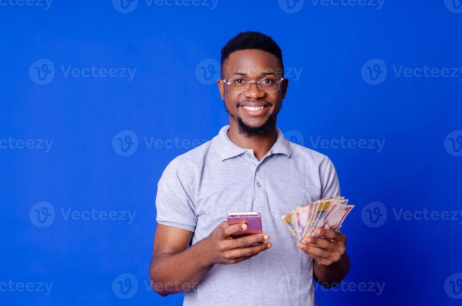 young african businessman holding a lot of money and using his phone photo