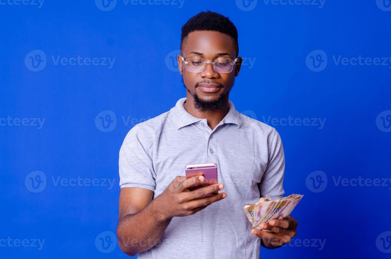 young african businessman holding a lot of money and using his phone photo