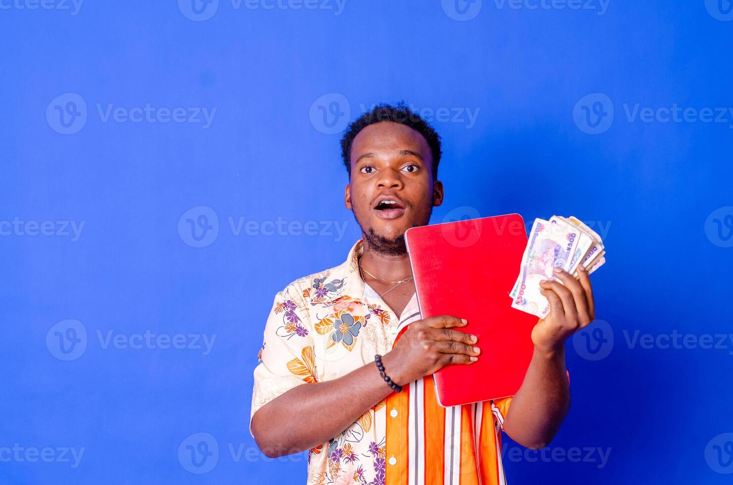 Portrait of excited young modern businessman standing holding laptop photo